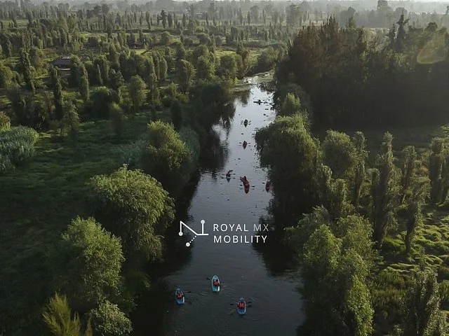 Luftaufnahme eines Kanals mit Kajaks und üppigem Grün in Xochimilco.